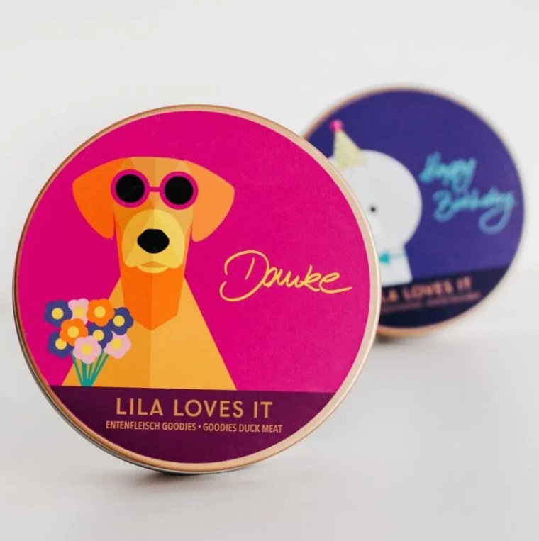 LILA LOVES IT dog treat tins featuring colorful designs for birthday gifts and special occasions.